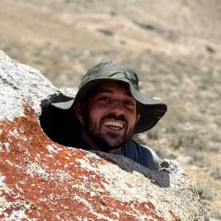 Martin with a green hat coming out of a boulder.